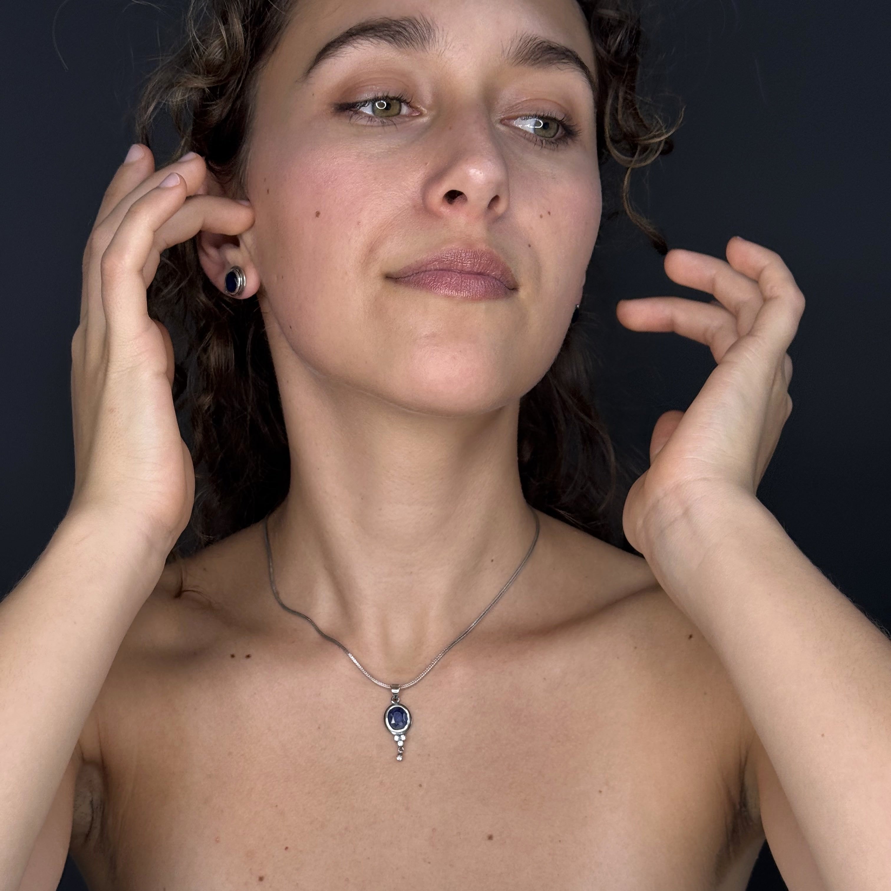 Woman wearing a necklace with a dark background