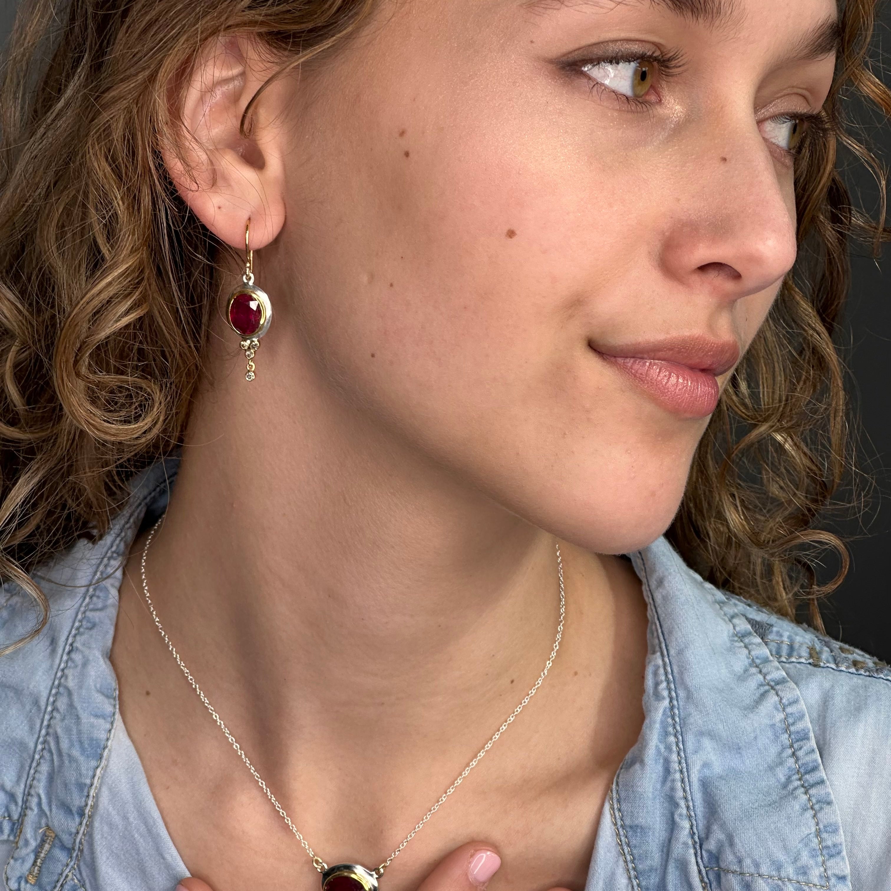 Close-up of a woman wearing a necklace and earrings with a dark background