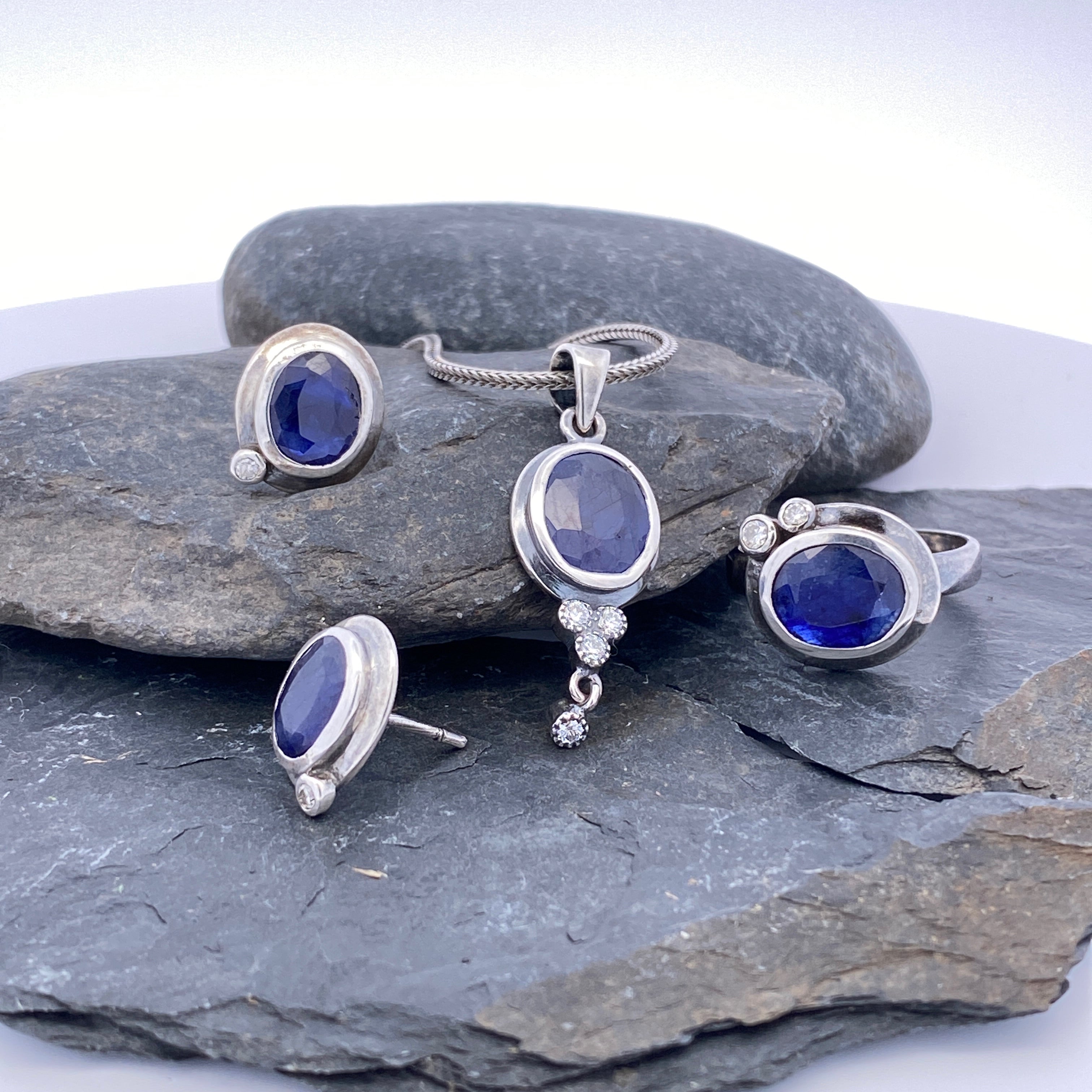 Silver jewelry set with blue stones on gray stones