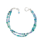 Multistrand beaded bracelet with blue and green beads on a white background