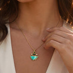 Woman wearing a necklace with a green pendant in a natural setting