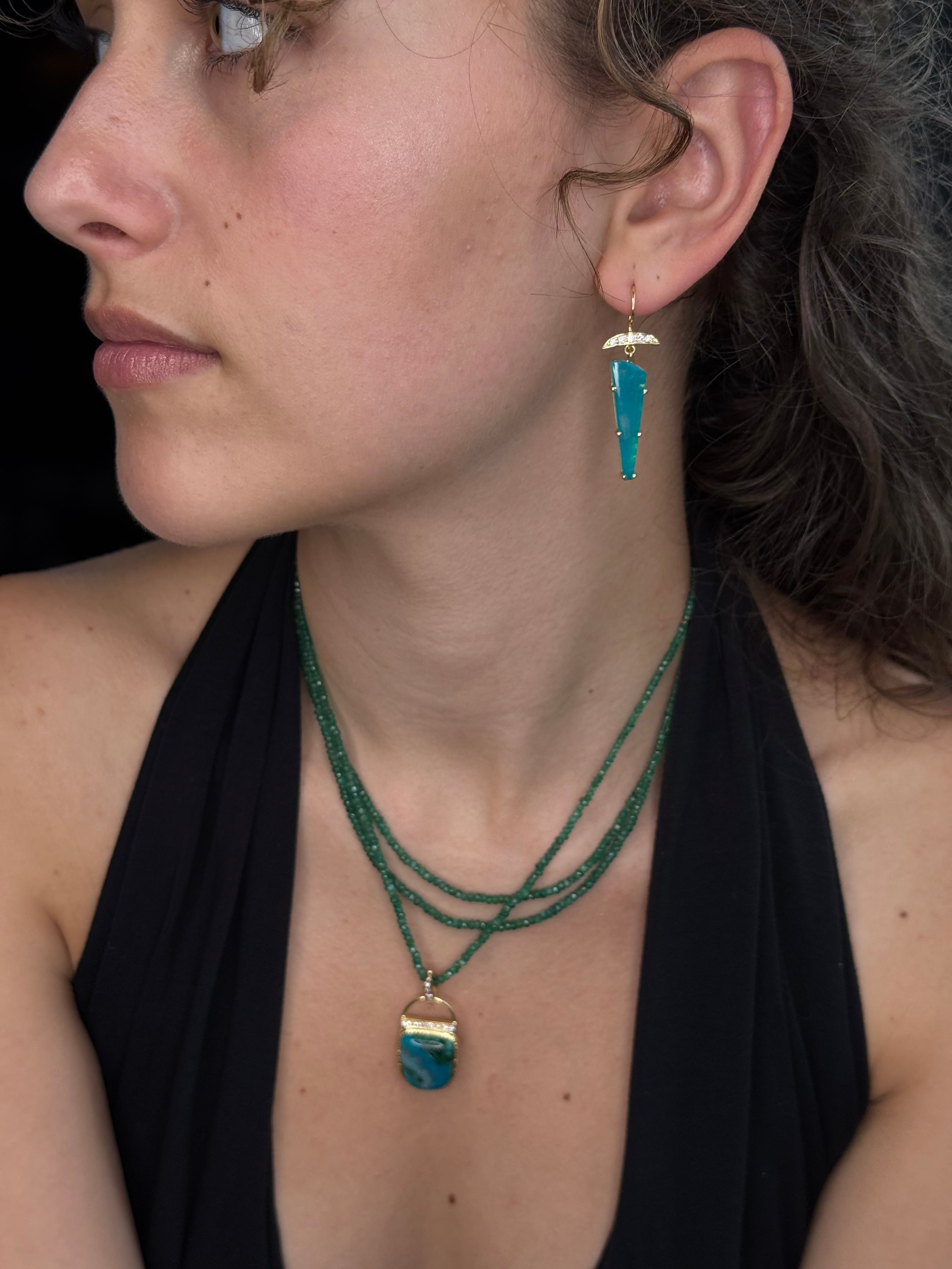 Close-up of a person wearing a green necklace with gold accents.