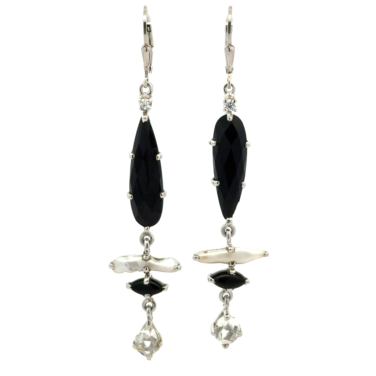 A pair of silver drop earrings featuring faceted black teardrop-shaped stones, a white stick pearl, a small black marquise stone, and clear crystal drops, shown against a plain white background.