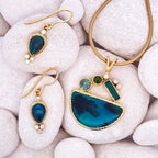 Gold and blue jewelry set on white stones