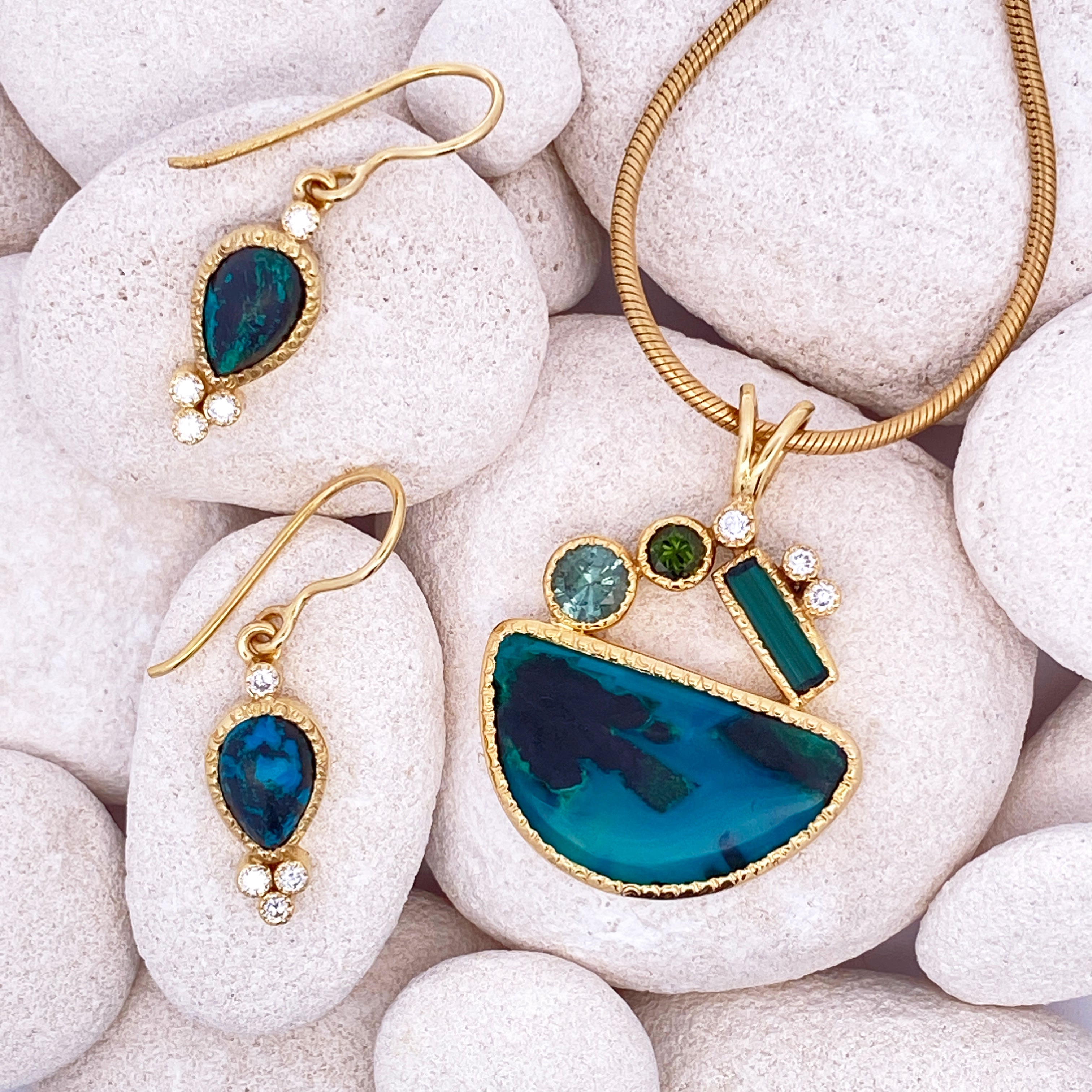 Gold and blue jewelry set on white stones