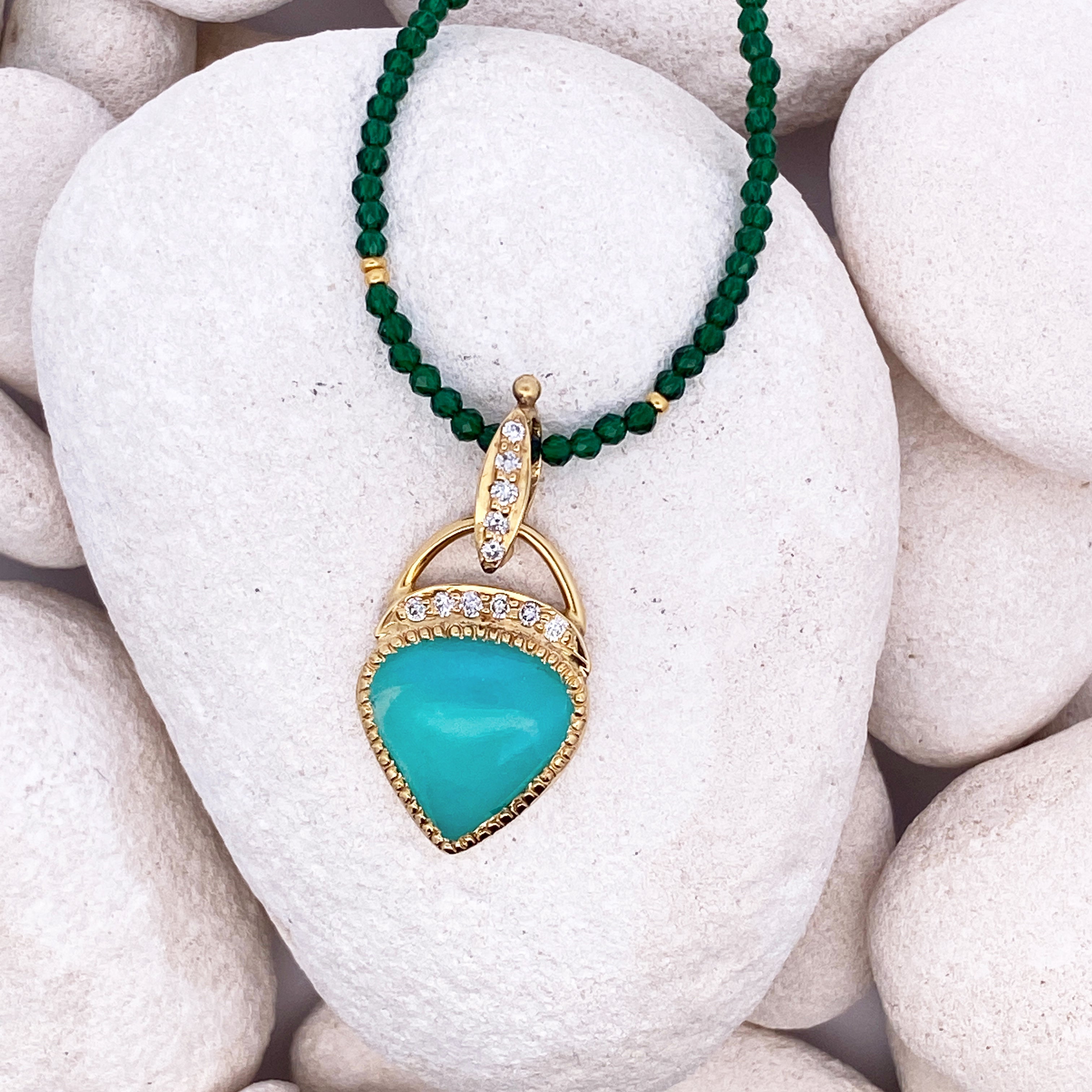 Necklace with a turquoise pendant and green beads on white stones