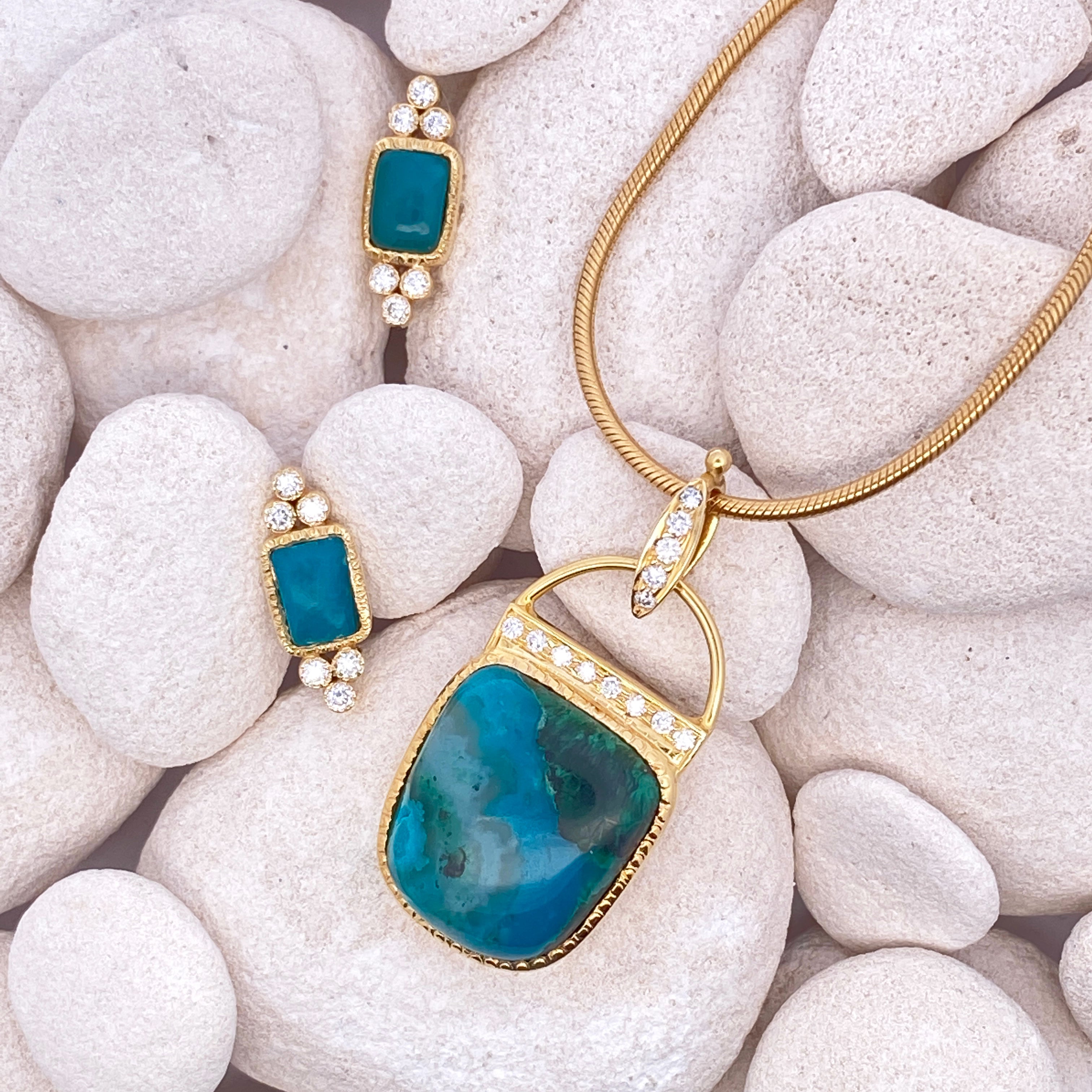 Gold and blue jewelry set on white stones