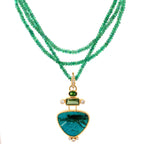 Green gemstone necklace with a gold pendant on a white background