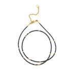 Black diamond beaded necklace with gold clasp on a white background