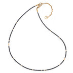 Necklace with black diamond beads and gold clasp on a white background