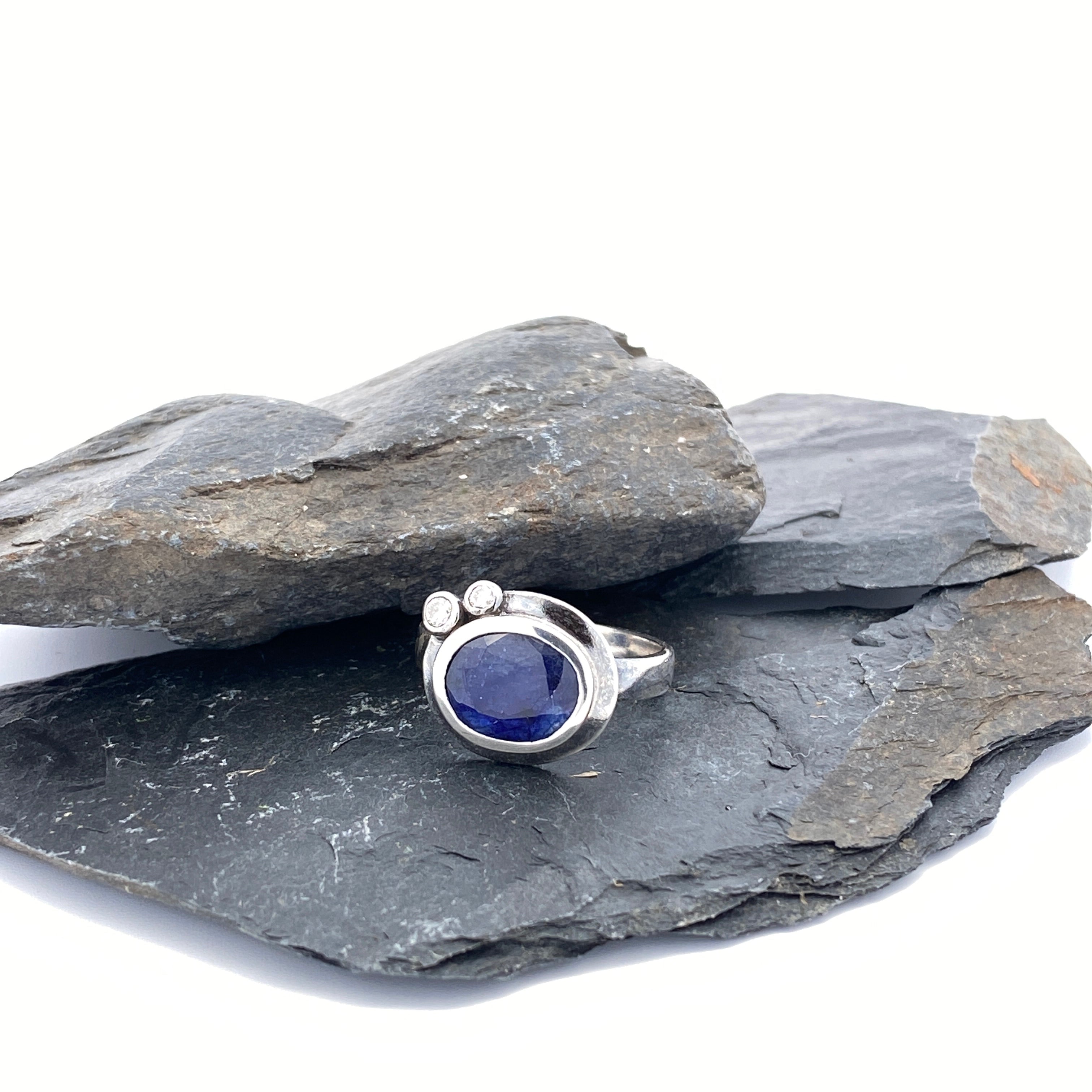 Silver ring with a blue stone on a stack of gray stones