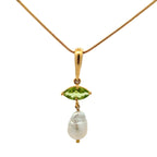 A gold pendant necklace featuring a marquise-cut green gemstone and a dangling baroque pearl, set on a delicate gold chain against a white background.