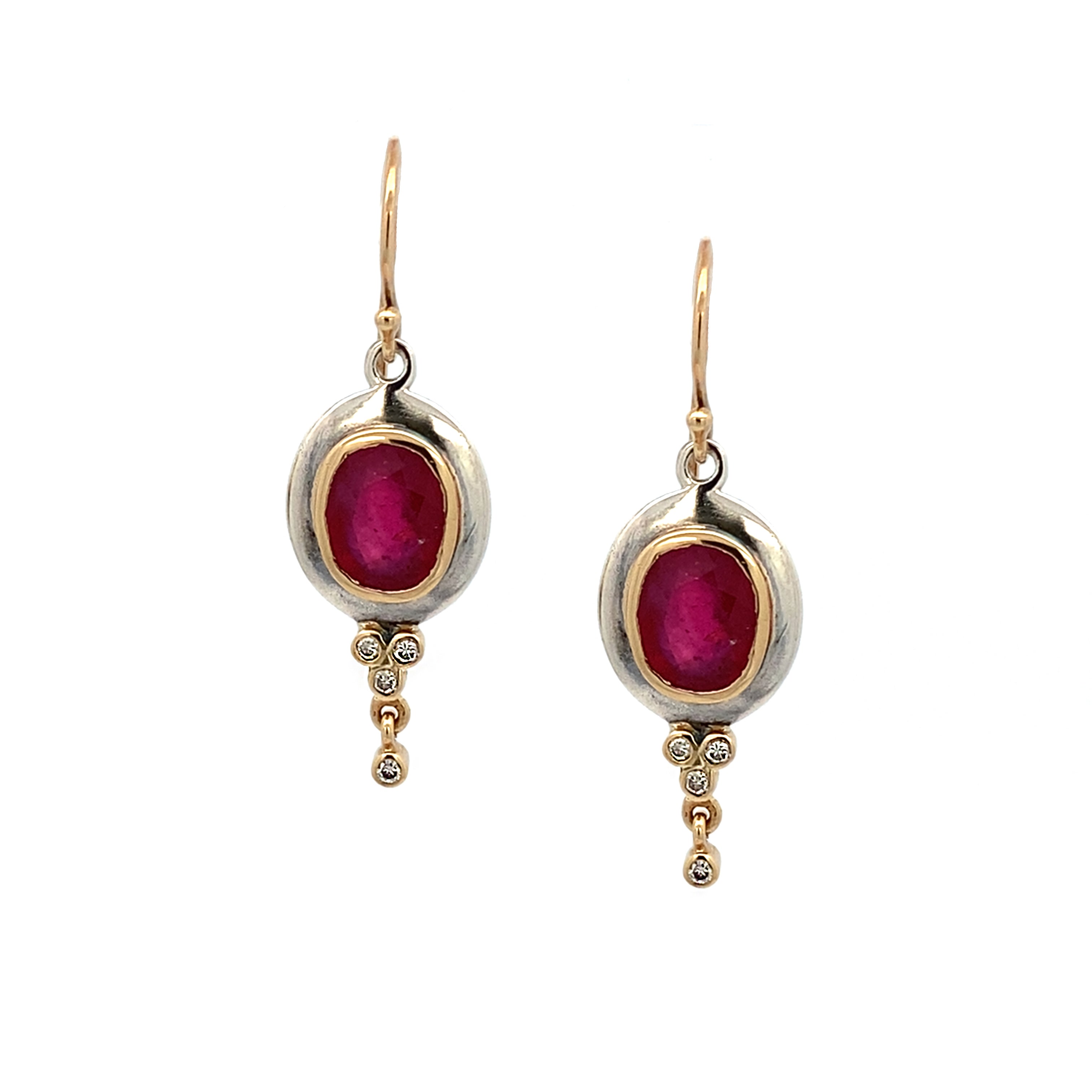 Pair of gold and silver earrings with red gemstones on a white background