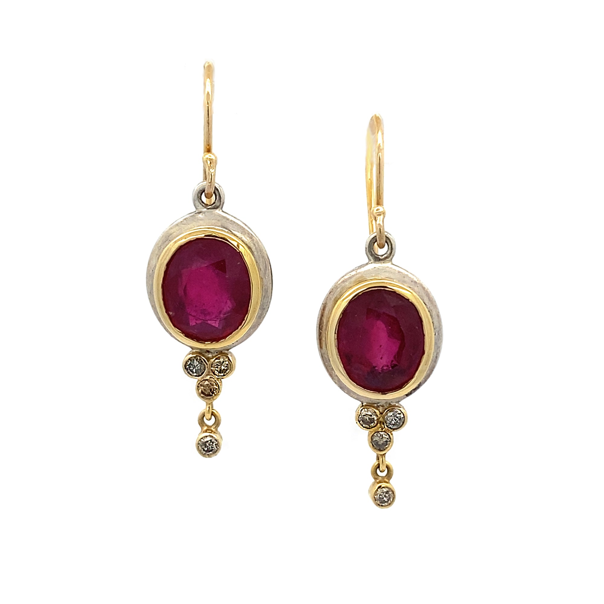 Gold earrings with red gemstones on a white background