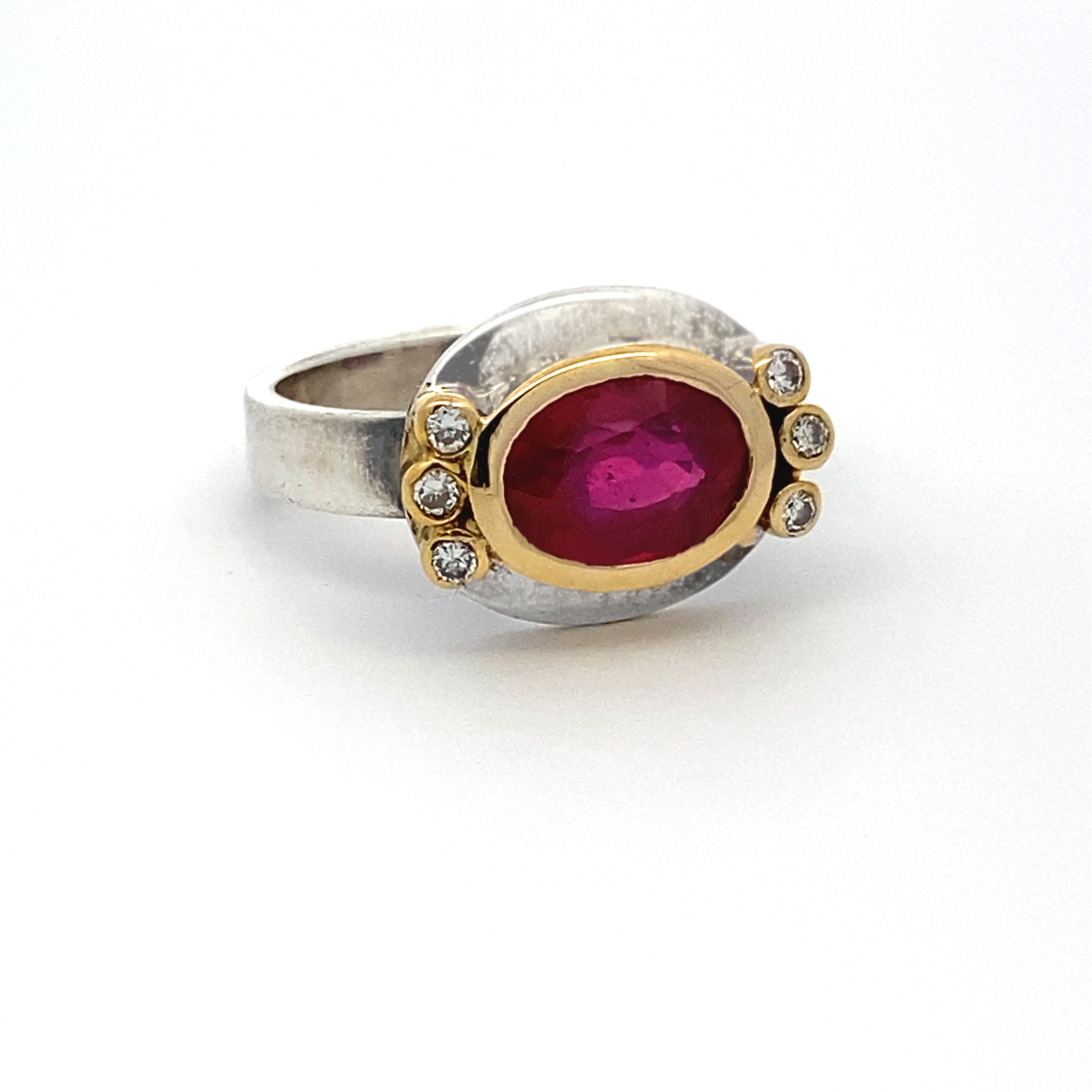 Ring with a red gemstone and gold accents on a white background