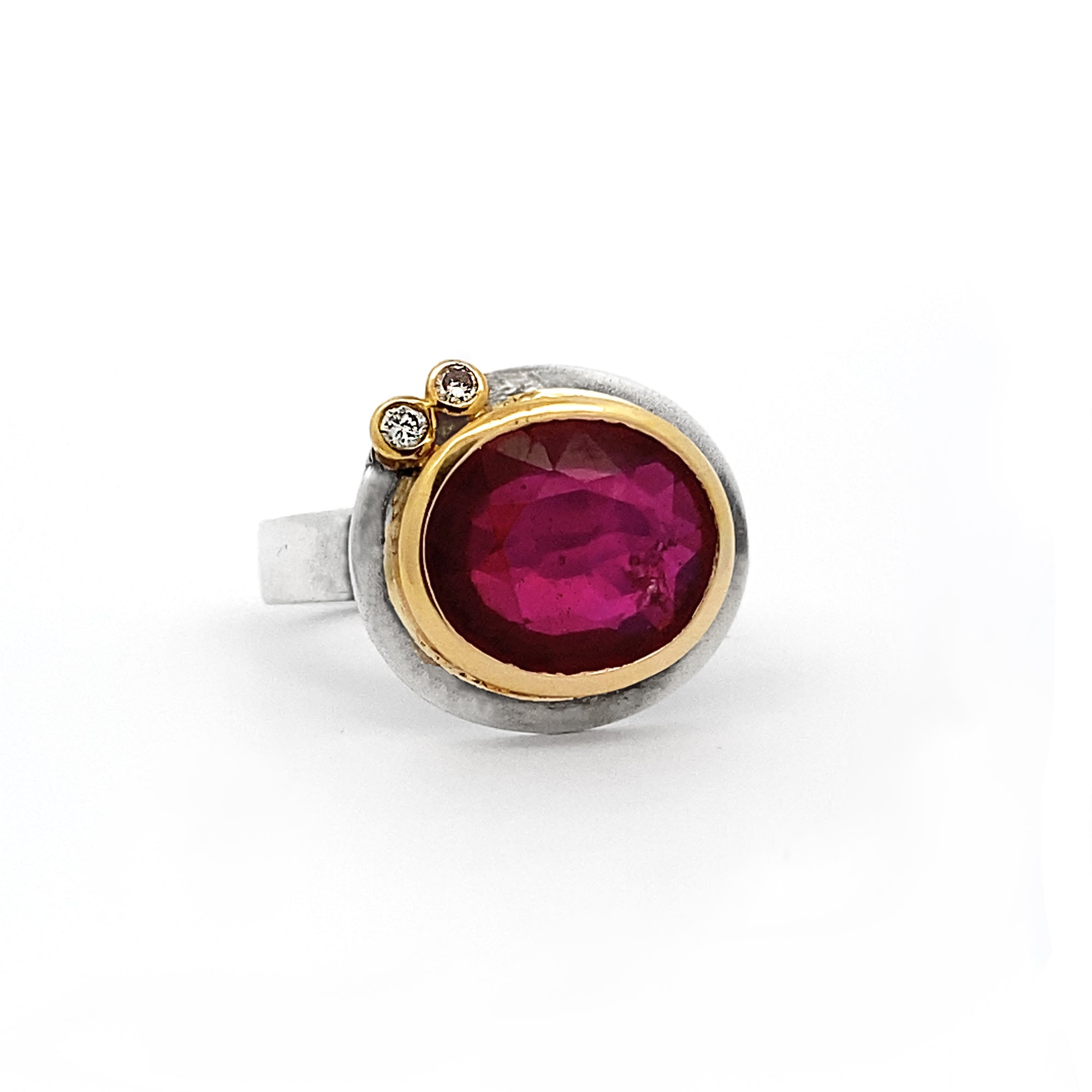 Ring with a red gemstone and gold accents on a white background