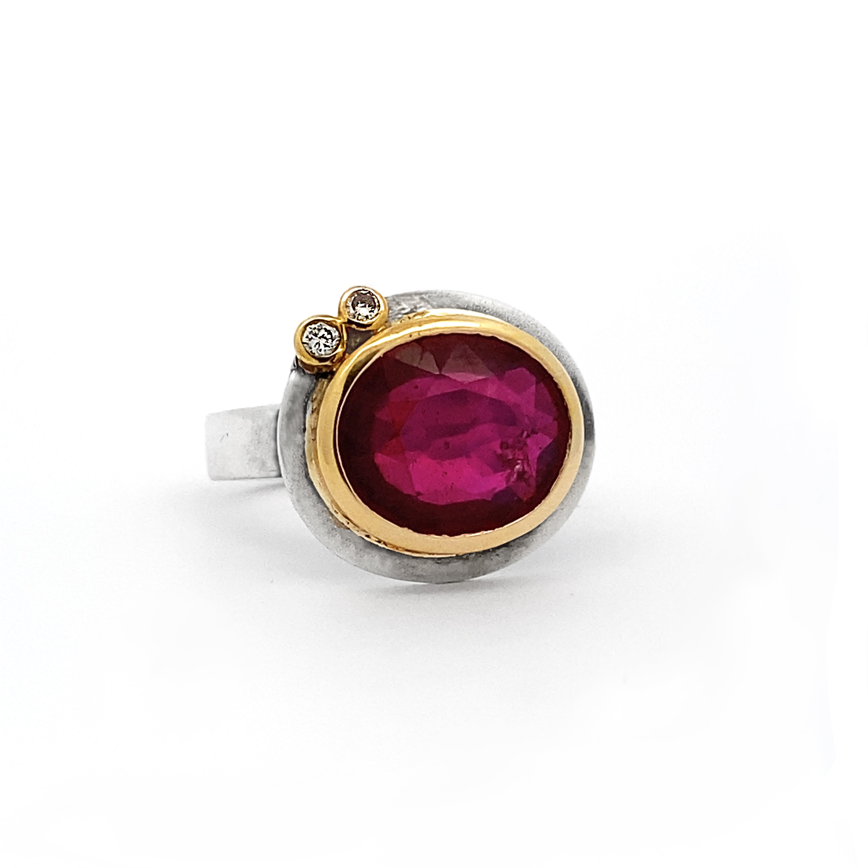 Ring with a red gemstone and gold accents on a white background
