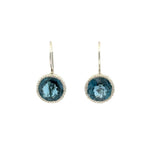 A pair of silver leverback earrings featuring round-cut deep blue gemstones surrounded by a textured silver, set against a plain white background.
